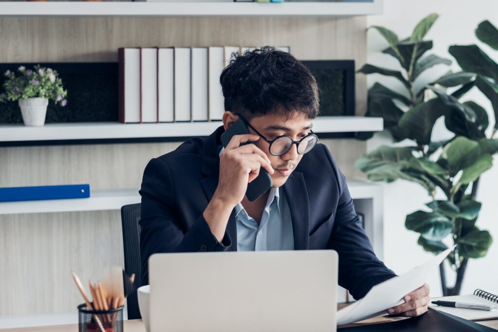 Asian businessman talking on smart phone contact with client